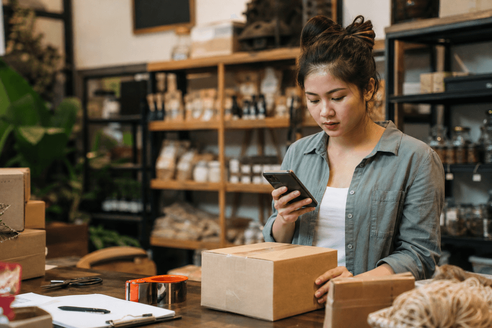 Chủ shop kiểm tra kiện hàng chuẩn bị gửi đi cho khách
