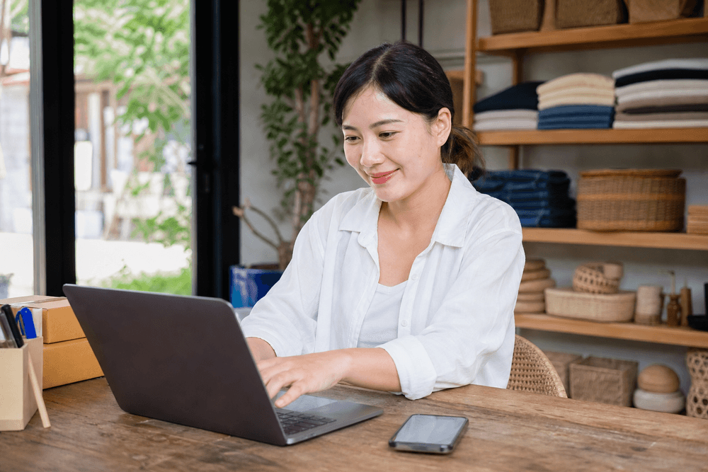 Chủ shop trả lời khách hàng lịch sự và chuyên nghiệp trên laptop